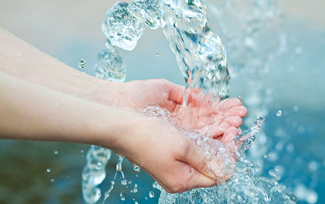 Hände an einem Wasserstrahl